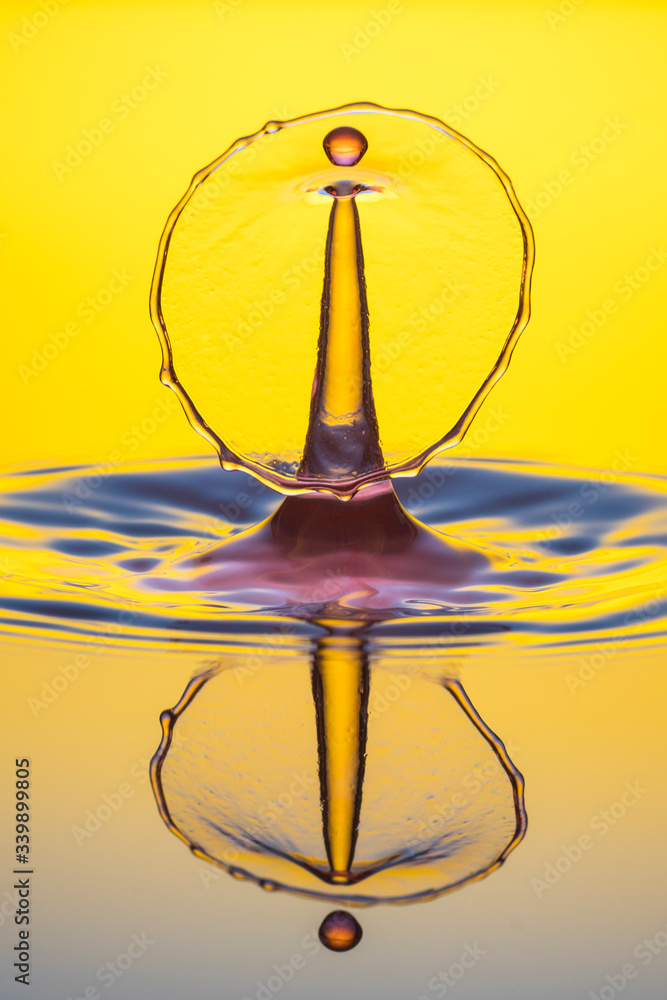water drop collision on yellow background water drop collision on yellow background