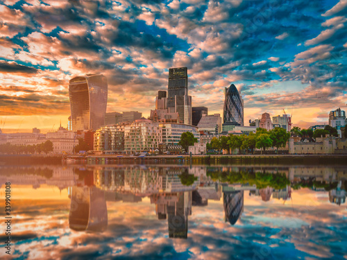 Skyscrapers of the City of London over the Thames river at sunset in England.