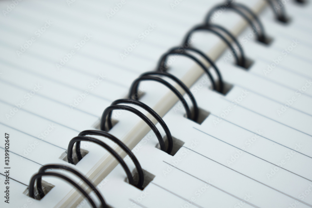 Close up picture of simple plastic spiral of a simple white paper diary Close up picture of simple plastic spiral of a simple white paper diary