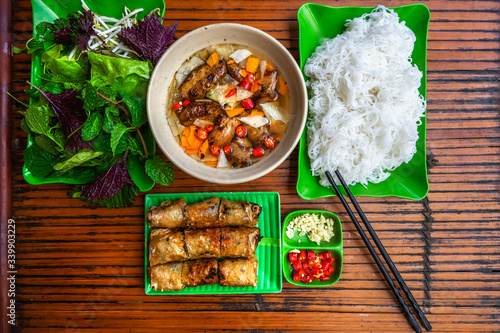 Barbecue cooking on fire - the ingredient of "bun cha", the famous Vietnamese vermicelli with spring roll, vermicelli, fish sauce and fresh vegetable served on bamboo background. From Ha Noi, Viet Nam