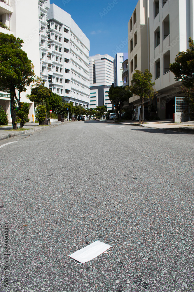 都会のビル群と道路に置かれたマスク