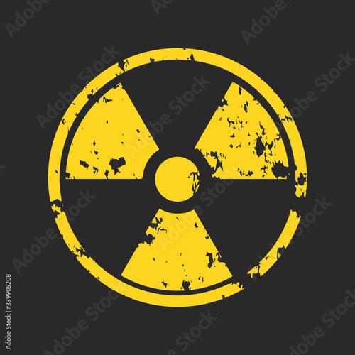 Photo Vector illustration of grunge yellow radioactive hazard warning sign painted over black background