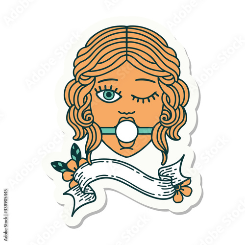 tattoo sticker with banner of winking female face with ball gag
