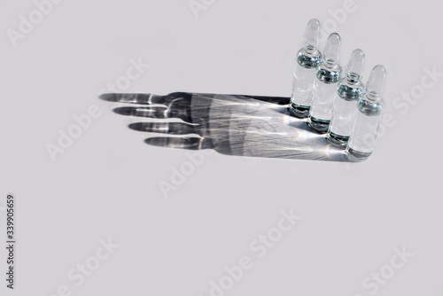Ampuls with anti-virus vaccine with transparent liquid on white background. Copy space. Space for text