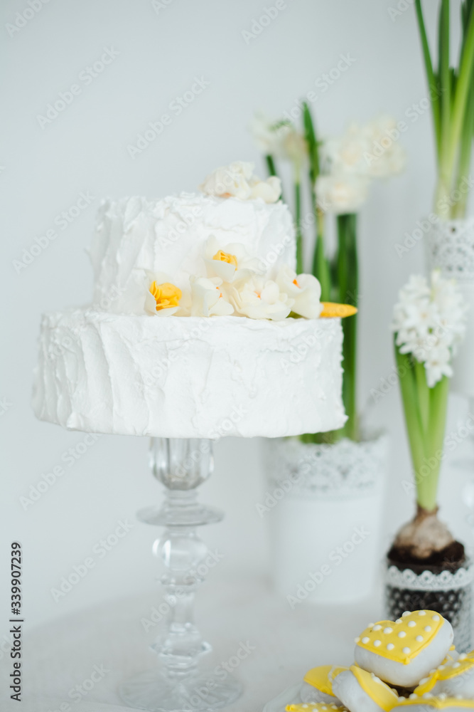 white cake hyacinths and yellow daffodils on the table white cake hyacinths and yellow daffodils on the table