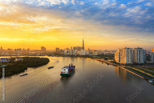 Aerial view of center Ho Chi Minh City, Vietnam with development buildings, transportation, energy power infrastructure. View from the Saigon river  with ships on the river. 