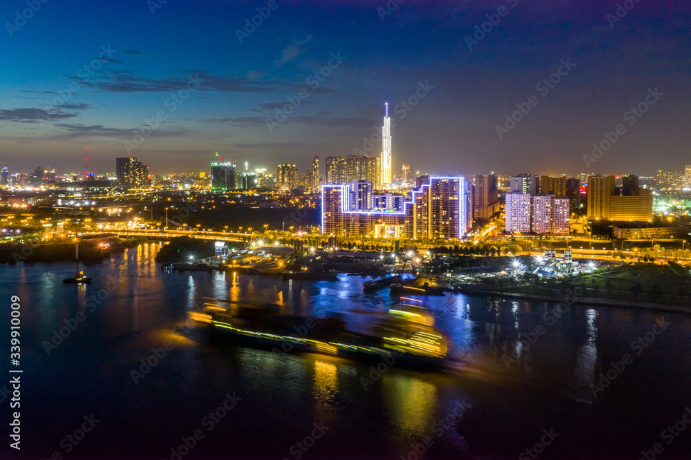 Shipping cargo to harbor by ship, aerial view. Center Ho Chi Minh City, Vietnam with development buildings, transportation, energy power infrastructure, view from Saigon river
