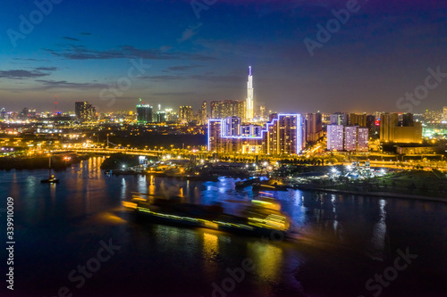 Shipping cargo to harbor by ship, aerial view. Center Ho Chi Minh City, Vietnam with development buildings, transportation, energy power infrastructure, view from Saigon river