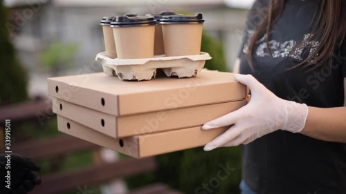 Closeup of courier give order to customer. Man from delivery service bring pizza and coffee. Hands in protective mask