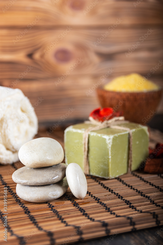 Composition with zen stones, towel, soap and salt on wooden background. Close up. Selective focus. Composition with zen stones, towel, soap and salt on wooden background. Close up. Selective focus.