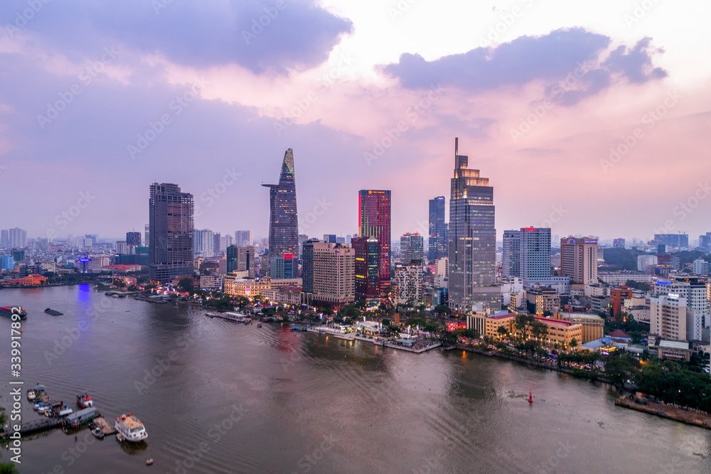 Fototapeta premium Top view aerial photo from flying drone of a Ho Chi Minh City with development buildings, transportation, energy power infrastructure. Financial and business centers in developed Vietnam.