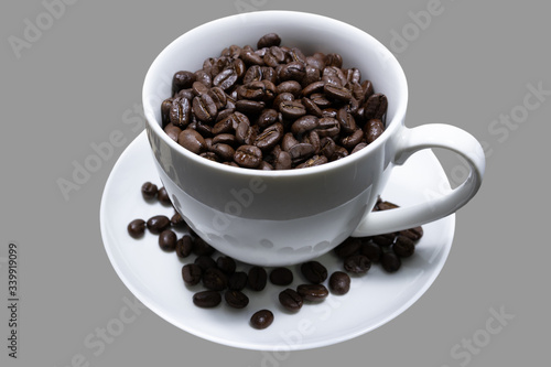 Coffee beans in a white mug on a gray background