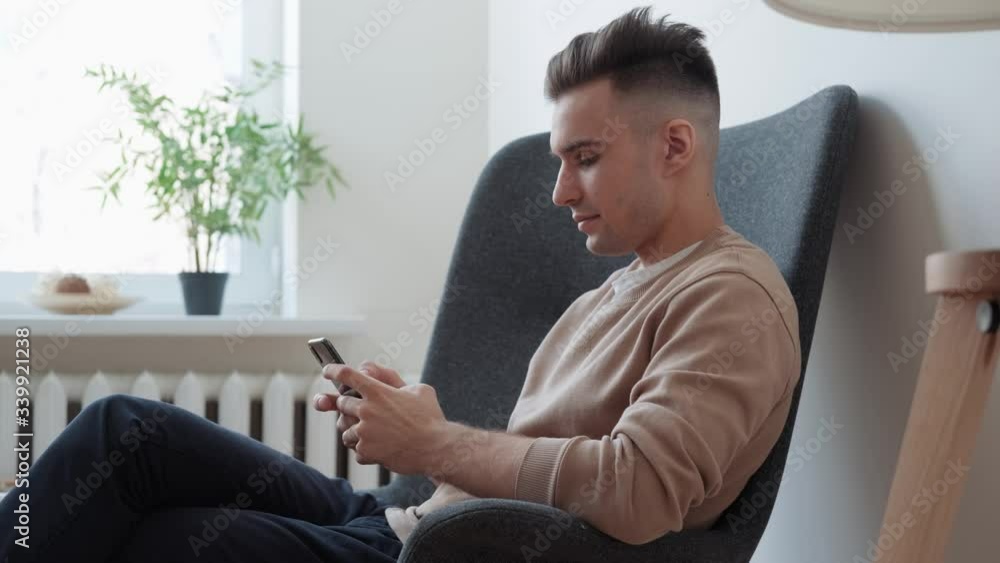 Professional creative man sitting in home office using smartphone. Professional creative man sitting in home office using smartphone.