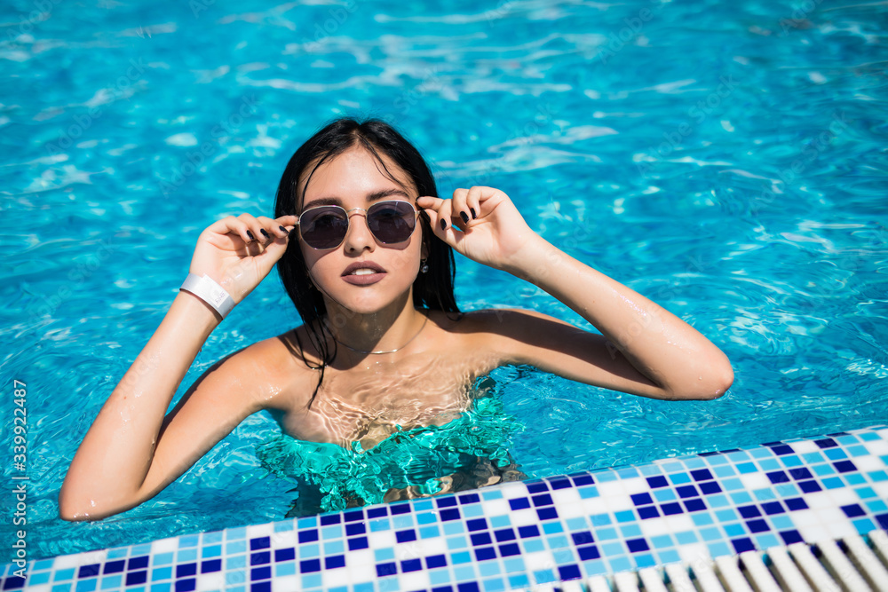 Beautiful young sexy woman in bikini at a pool