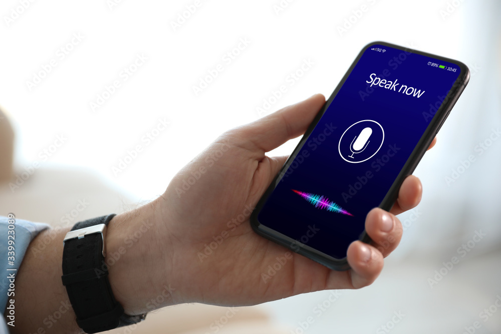 Man using voice search on smartphone indoors, closeup Man using voice search on smartphone indoors, closeup
