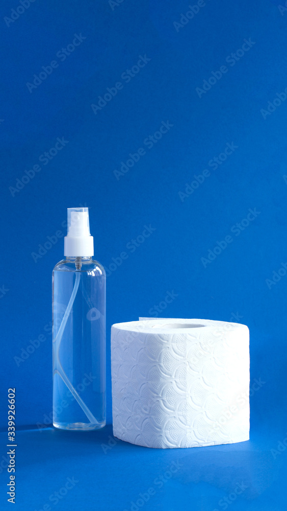 Bottle of anitizer and white toilet paper on the blue background Bottle of anitizer and white toilet paper on the blue background