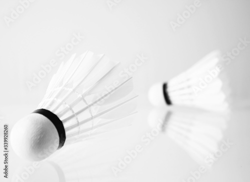 Shuttlecock against white on reflective surface