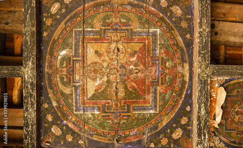 An ancient, fading mural representing the Tibetan Buddhist motif of the wheel of life on the wooden ceiling of an old monastery in the village of Tukuche on the Annapurna Circuit in Nepal. photo