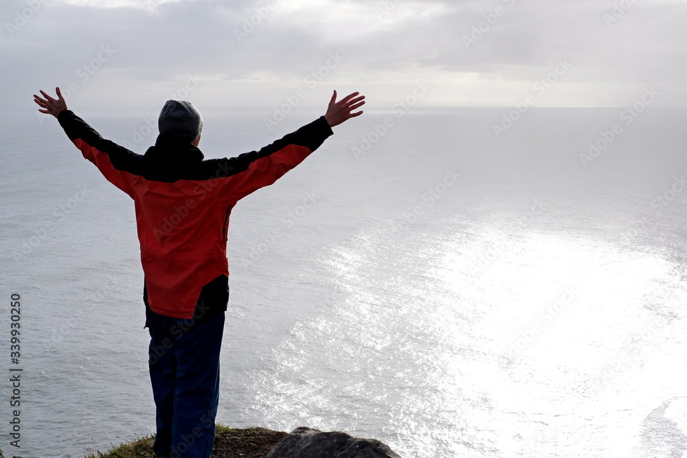 Man on a rock overlooking the sea Man on a rock overlooking the sea