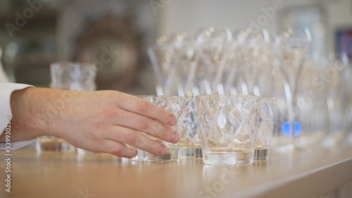 Clean plates, glasses and cutlery on wooden table. Catering set-up ready for the event to begin. ervice area the waiter in restaurant. the waiter sets the glasses photo