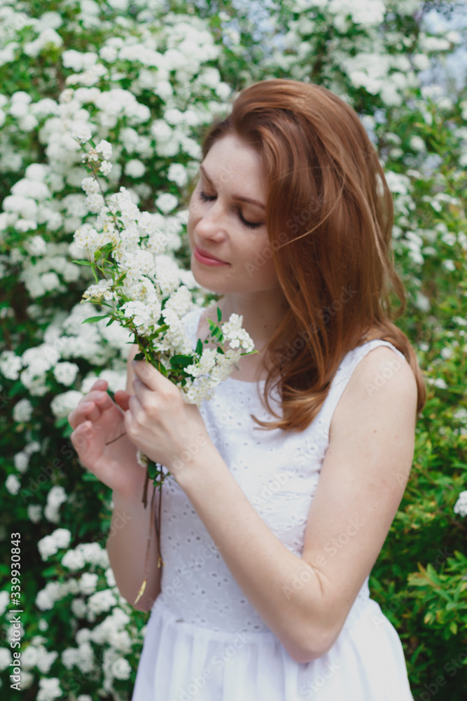 beautiful red-haired woman with freckles surrounded by white flowers beautiful red-haired woman with freckles surrounded by white flowers