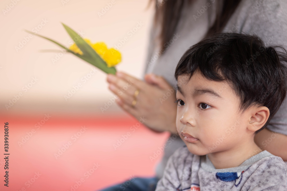 Little boy with yellow flower, paying respect to a Buddha image in Thailand temple. Little boy with yellow flower, paying respect to a Buddha image in Thailand temple.