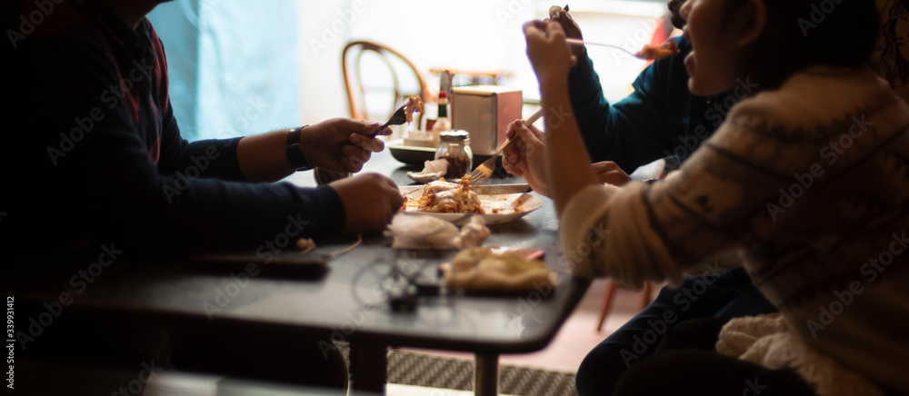 Silhouette of a group of young friends having lunch in a restaurant in a festive day. Indian lifestyle.