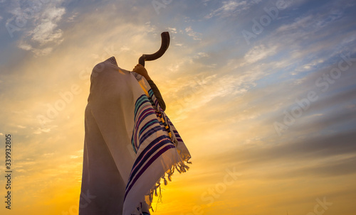 Photo Blowing the Shofar - man in a tallith, Jewish prayer shawl is blowing the shofar