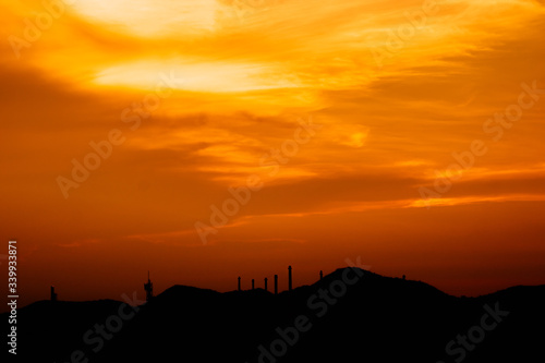 The skyline of the mountains and the oil production industry There is an orange-red light during the sunset. silhouette industrial. © Nanthicha Khamphumee