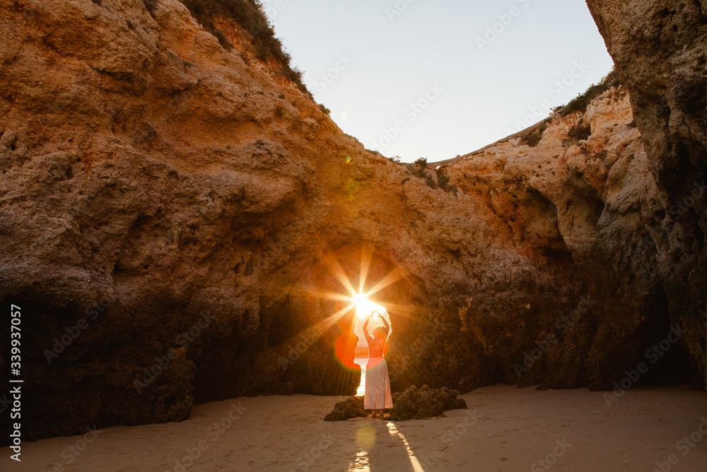 © Matt & Lena - Woman holding a sunburst in the beach coves of Algarve, Portugal