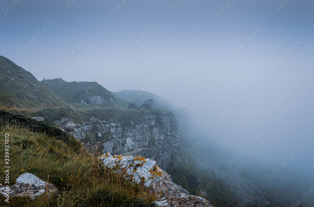 Cliff top view of the jurassic coast cliffs during foggy weather near Tout Quarry, Isle of Portland, Dorset, UK