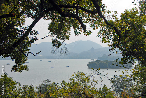 West Lake (Xi Hu) in Hangzhou, Zhejiang Province, China. View through the trees towards Leifeng Pagoda from Gushan Hill on the north shore of West Lake. West Lake is a tourist sight in Hangzhou. photo