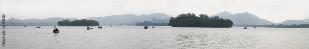 West Lake (Xi Hu) in Hangzhou, Zhejiang Province, China. Panoramic view of West Lake with tourist boats looking towards Leifeng Pagoda, City God Pavilion and islands. West Lake panorama, Hangzhou.