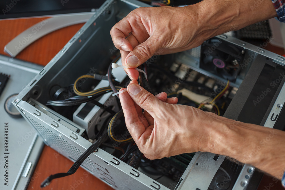 Hands of a man repairing a computer.
