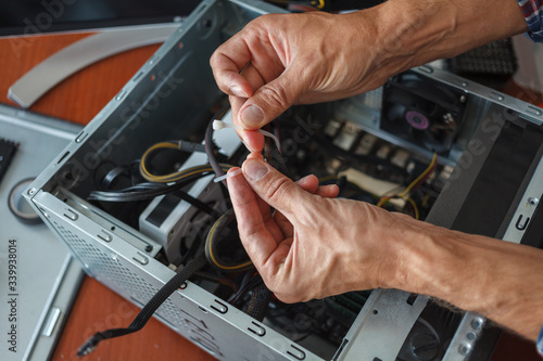 Hands of a man repairing a computer.
