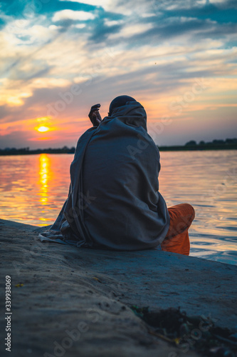 monk sitting next to river