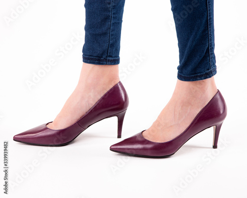 Stylish fashionable women's shoes on legs on a white background in studio