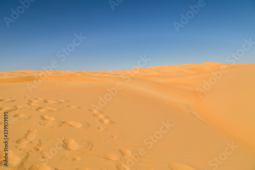 Desert landscape flat at Rub' al Khali empty, foot marks
