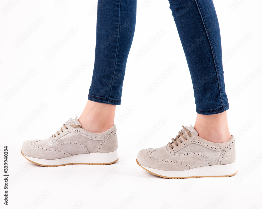 Stylish fashionable women's shoes on legs on a white background in studio Stylish fashionable women's shoes on legs on a white background in studio
