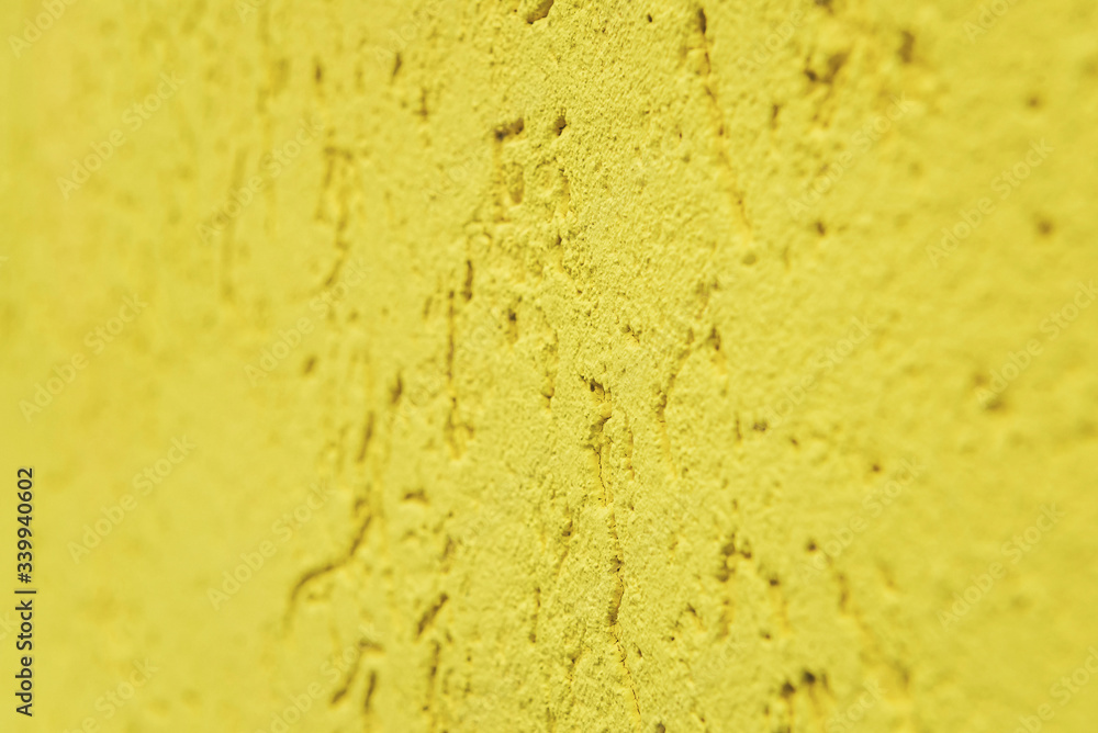 Fototapeta premium yellow cement wall, building facade as a color relief texture close-up, copy space