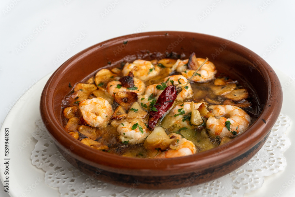 Shrimp Pil Pil with olive oil and garlic cooked in a clay pot dish Shrimp Pil Pil with olive oil and garlic cooked in a clay pot dish