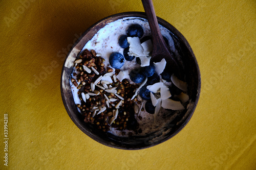 Healthy snack, yoghurt with blueberries, coconut, granola and seeds