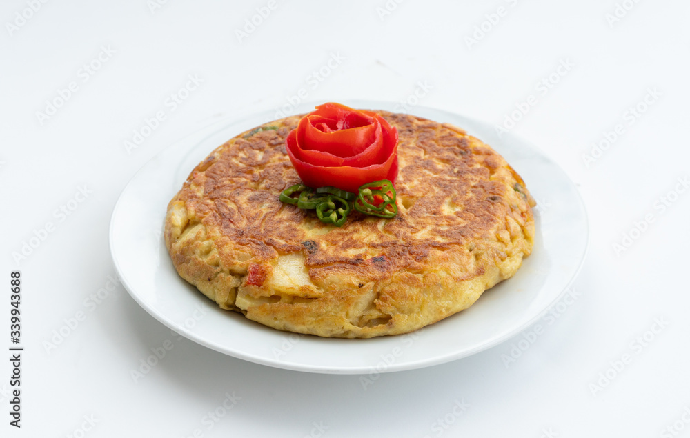 Tortilla espanola, Spanish omelette with potatoes with a tomato flower on top Tortilla espanola, Spanish omelette with potatoes with a tomato flower on top