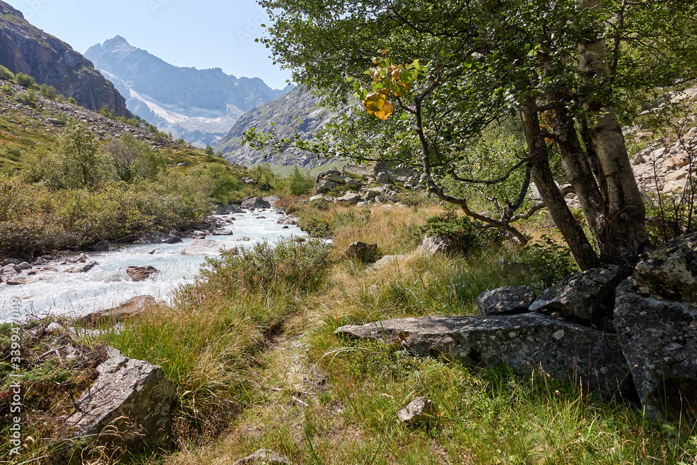 Mountain river landscape. Alps. In the morning in clear sunny day on a wide corner. The river quickly flows. Mountaineering and hikes. Beauty. Blue. Mountain river landscape. Alps. In the morning in clear sunny day on a wide corner. The river quickly flows. Mountaineering and hikes. Beauty. Blue.