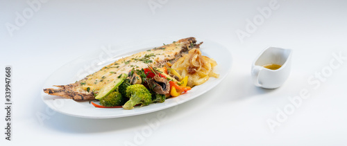 Photography Sole meunière fish with grilled vegetables and caramelized onions on a white plate with white background