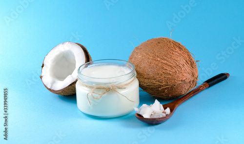 coconuts, milk, and a spoon with coconut on a blue background