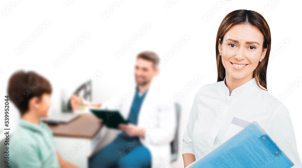 Portrait of a female pediatrician, the doctor smiles and looks at the camera. Doctor doing medical exam child, on the background. Portrait of a female pediatrician, the doctor smiles and looks at the camera. Doctor doing medical exam child, on the background.