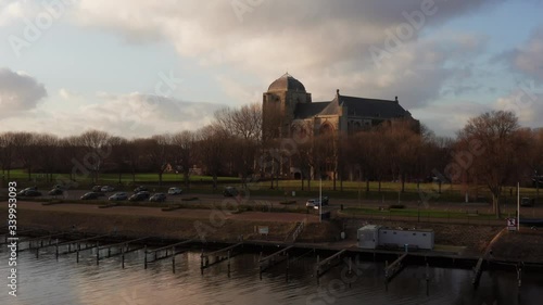 Revealing shot of the big Church of Veere from the canal. Slow drone shot from low to high angle. photo