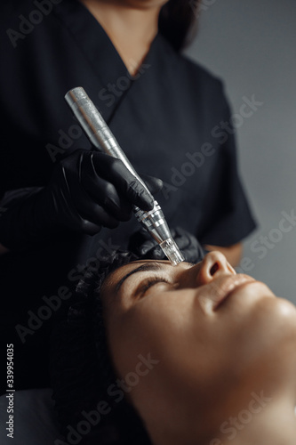 Cosmetologist make procedure for cleaning skin with steel tool from blackheads and acne in cosmetology center. photo