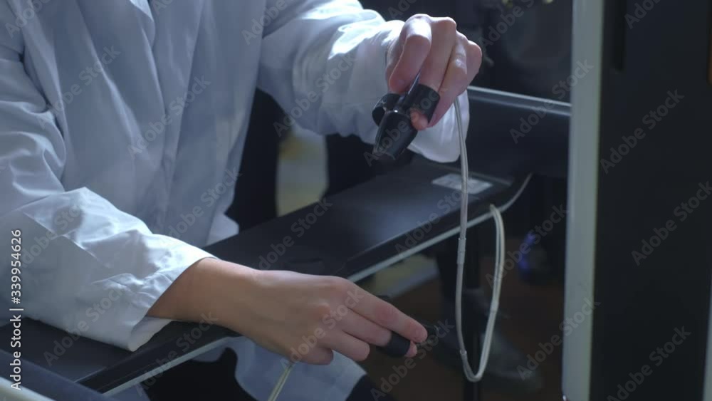 A girl surgeon performs an operation on a patient in virtual reality. Manages the arms of the robotic arms. New technologies in medicine, innovations. Remote treatment of cancer patients and infected A girl surgeon performs an operation on a patient in virtual reality. Manages the arms of the robotic arms. New technologies in medicine, innovations. Remote treatment of cancer patients and infected